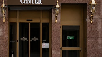 Fachada del Hotel King's Center con un cartel sobre la entrada, dos puertas y dos lámparas en la pared.