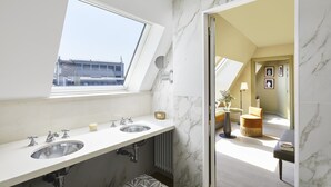 Ein modernes Badezimmer mit Oberlicht, zwei Waschbecken, einem Spiegel und einer Heizung.