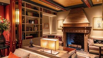 Ein gemütliches Wohnzimmer mit Kamin, Bücherregalen und einer bequemen Sitzecke.