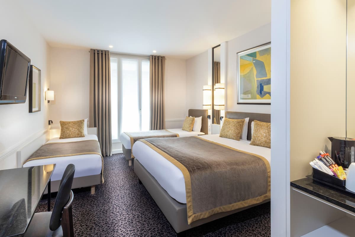 A hotel room with two beds, a desk, a chair, a television, and a painting on the wall.