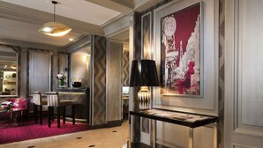 A lobby with a red carpet, a bar area, and a wall-mounted lamp. - Elysees Union Hotel (Paris)