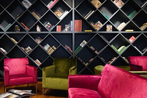 Una biblioteca con scaffali e quattro sedie.