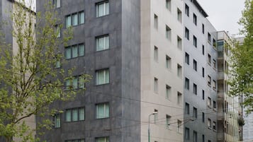 Um hotel de vários andares com design moderno, apresentando um telhado plano e fachada uniforme.