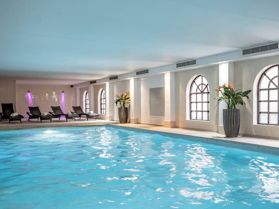 Una piscina techada, sillones reclinables de piscina