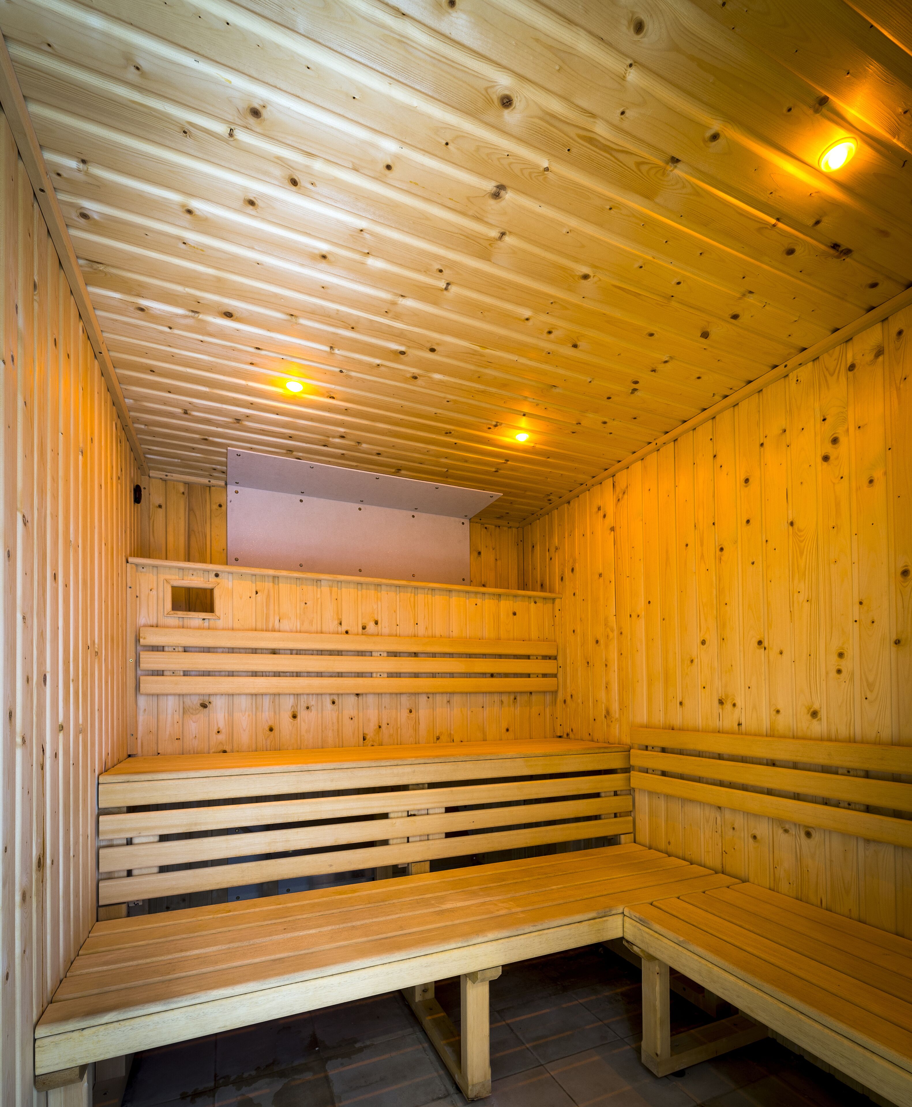 Una sauna con bancos de madera y techo inclinado.