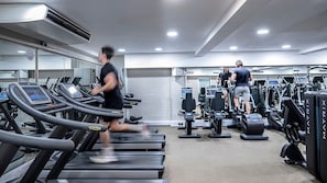 A gym with treadmills, elliptical machines, and weight equipment.