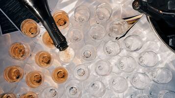 Un balde de hielo con varias copas de vino y una botella de champán.
