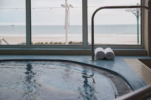 A hot tub with a view of the beach, a towel rack, and a window with a view of the ocean. - L'Horizon Beach Hotel & Spa (St. Brelade)