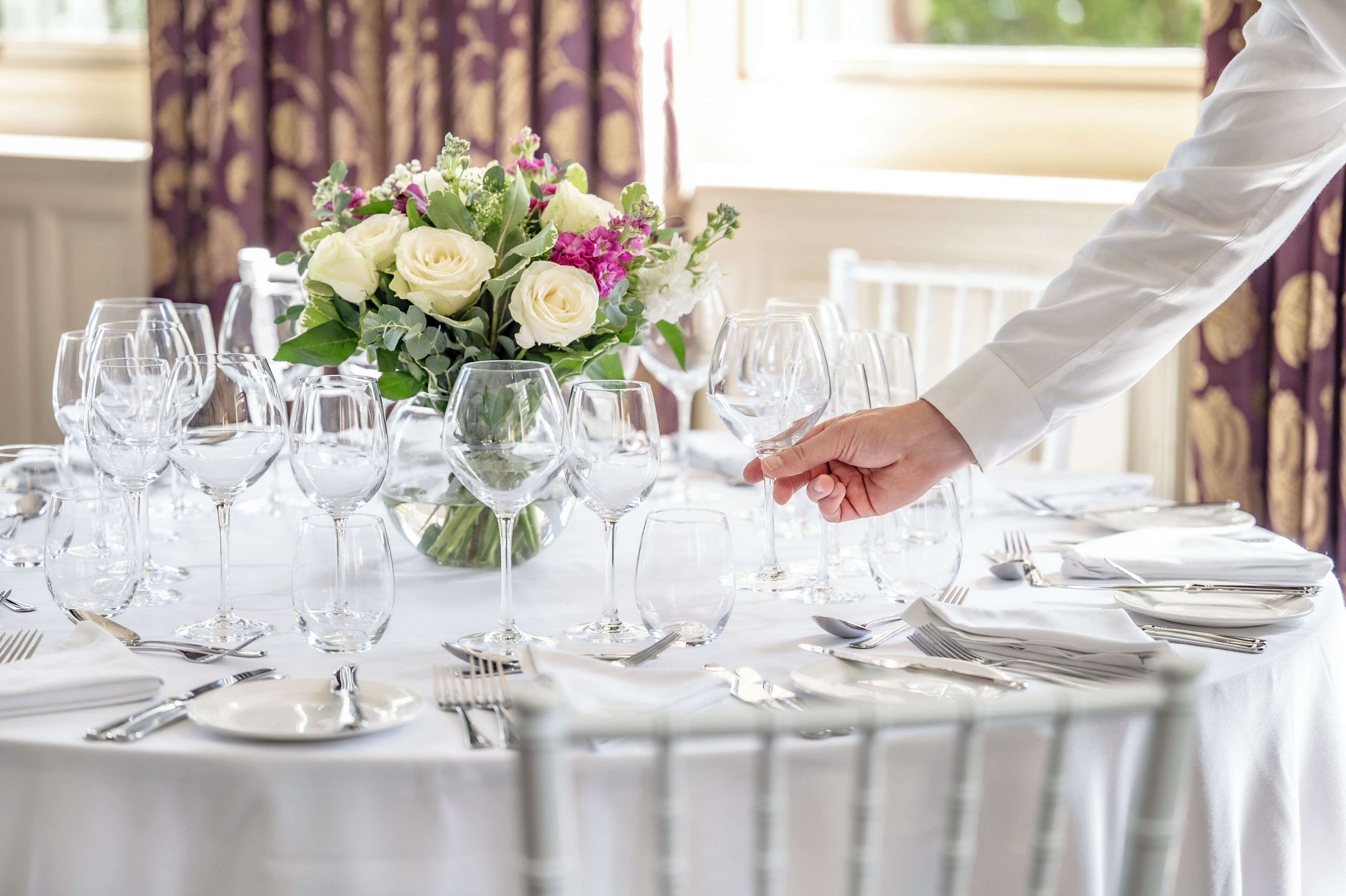 Une table dressée pour un dîner formel, agrémentée d’un centre de table floral.
