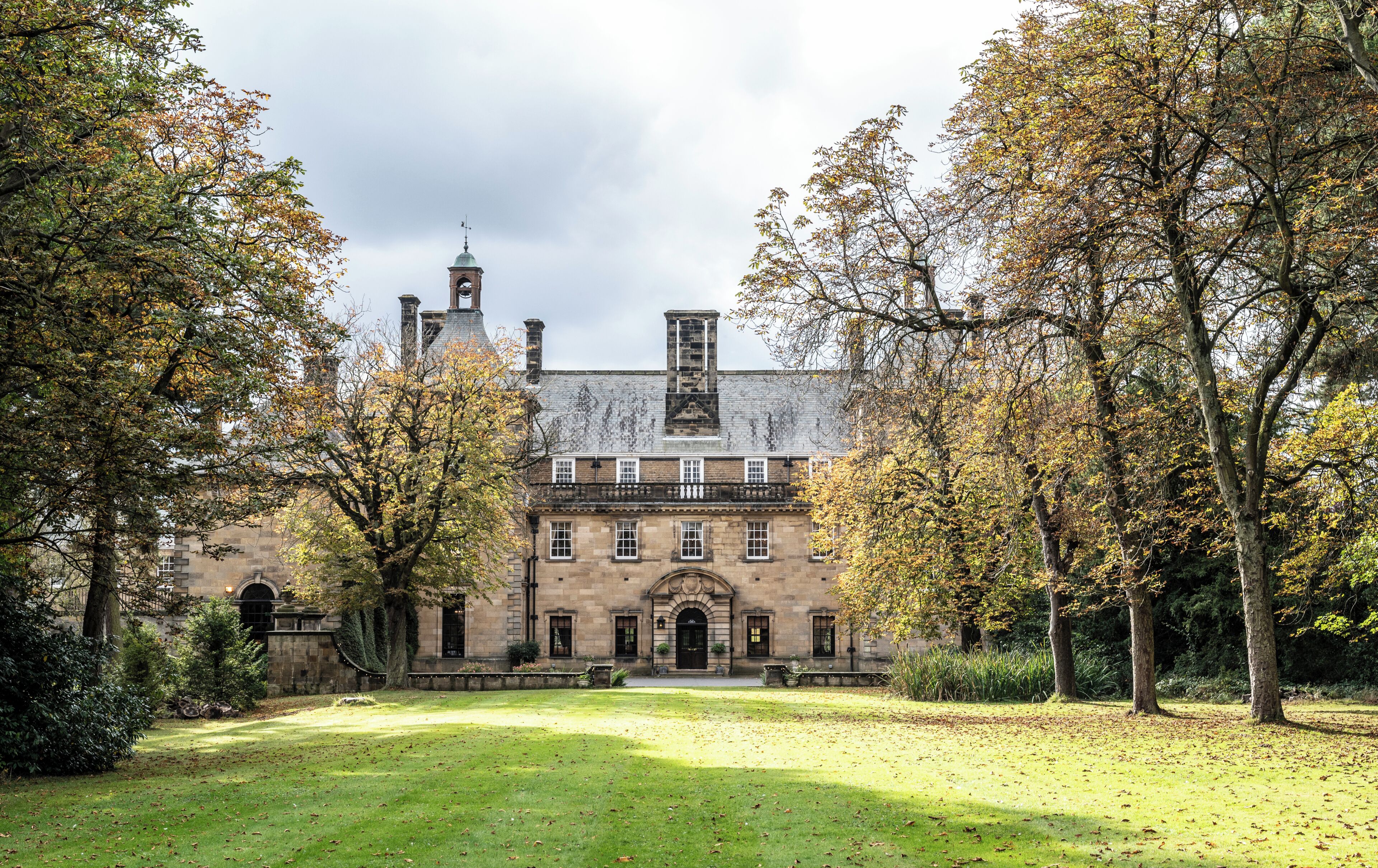 A historic building with a symmetrical facade, arched windows, and a central entrance.
