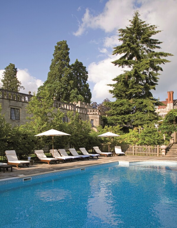 Piscine extérieure en saison, parasols, chaises longues
