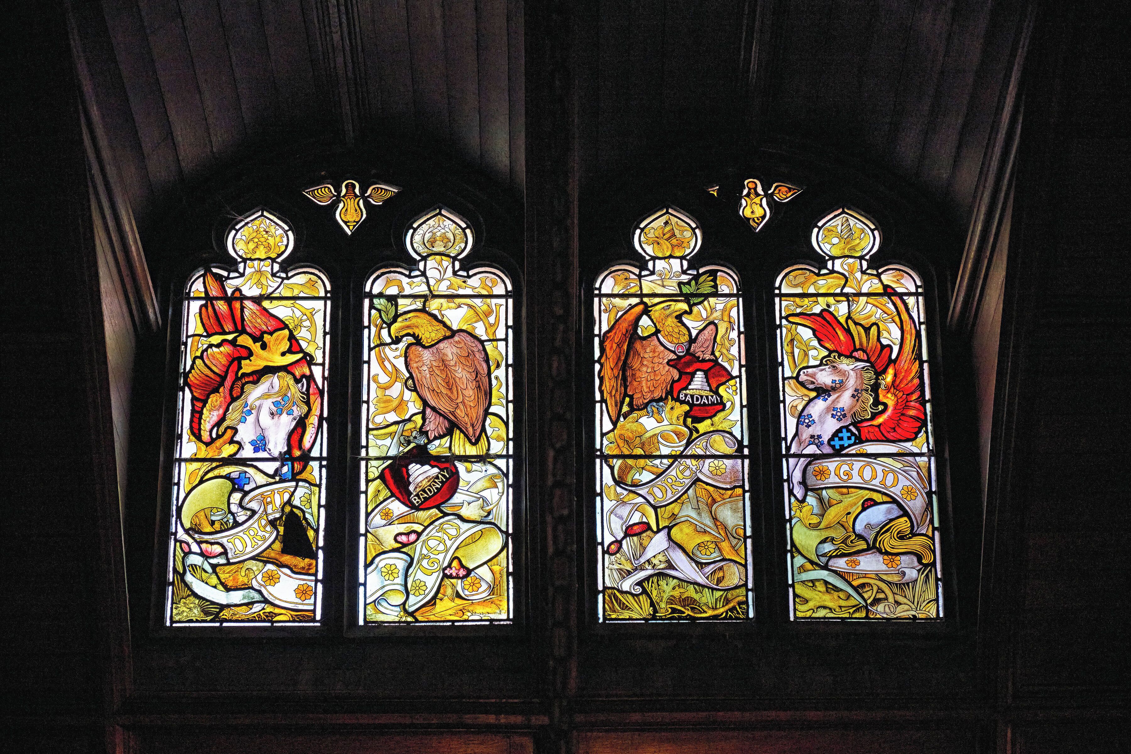 A stained glass window with four panels, each depicting different scenes.