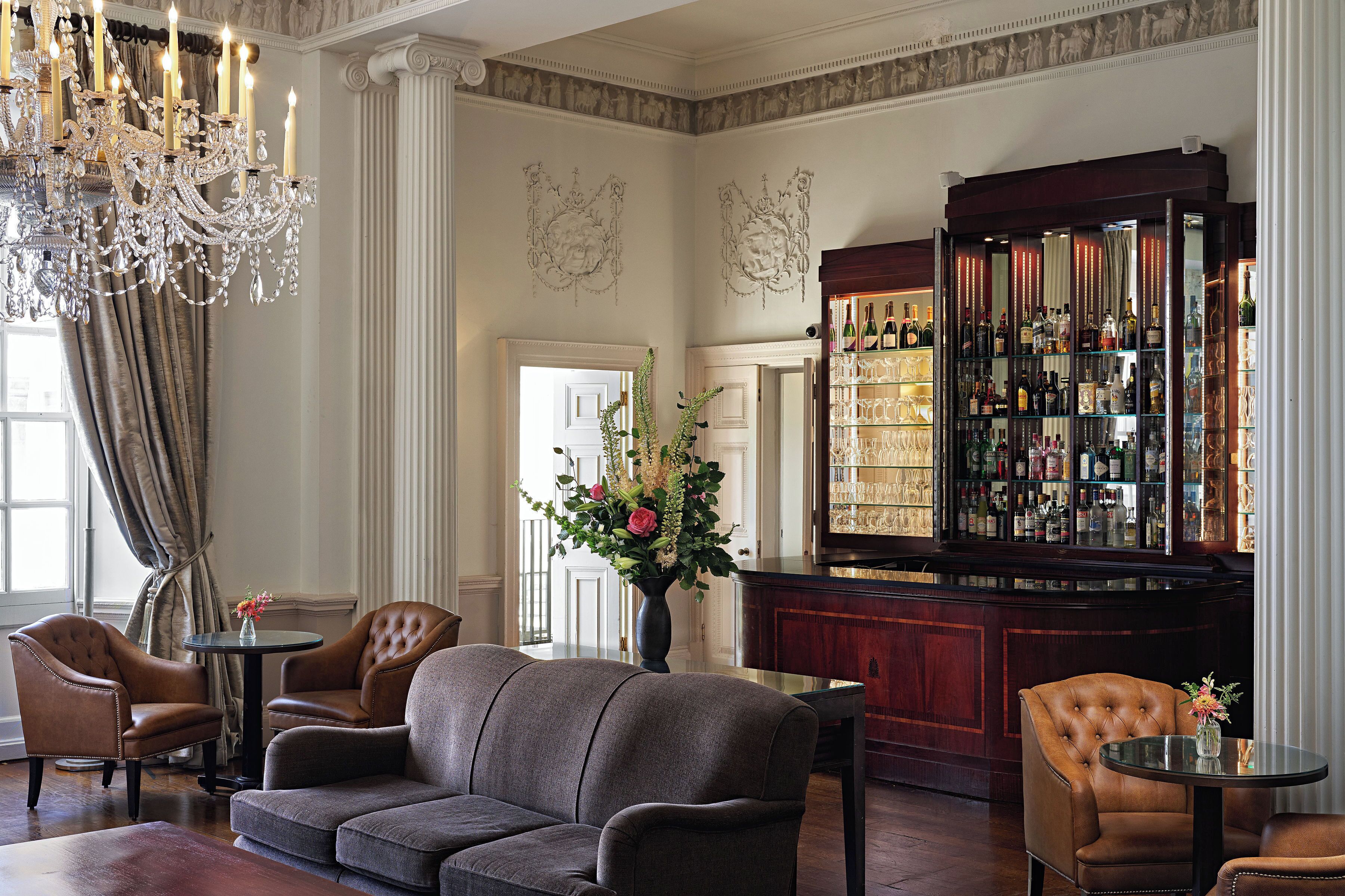 A bar area with a large liquor display, a chandelier, and seating arrangements.