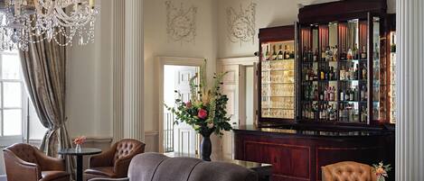 A bar area with a large liquor display, a chandelier, and seating arrangements.