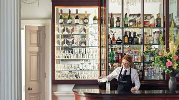 Eine Bar mit einem Barkeeper, Regalen voller Spirituosenflaschen und einer Dekoration an der Wand.