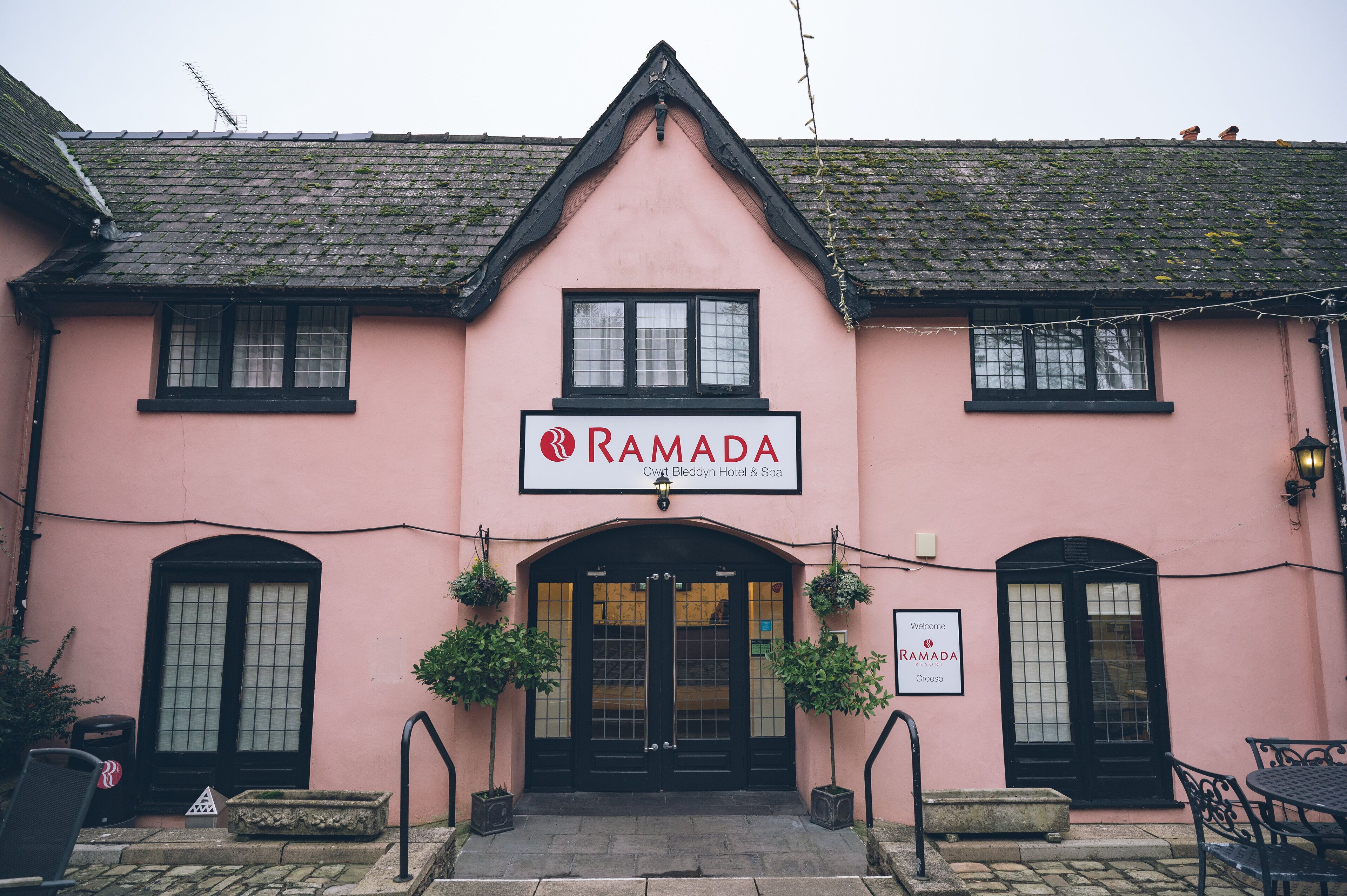 En rosa bygning med et skilt, der viser "RAMADA" og "Cwt Bleddyn Hotel & Spa".