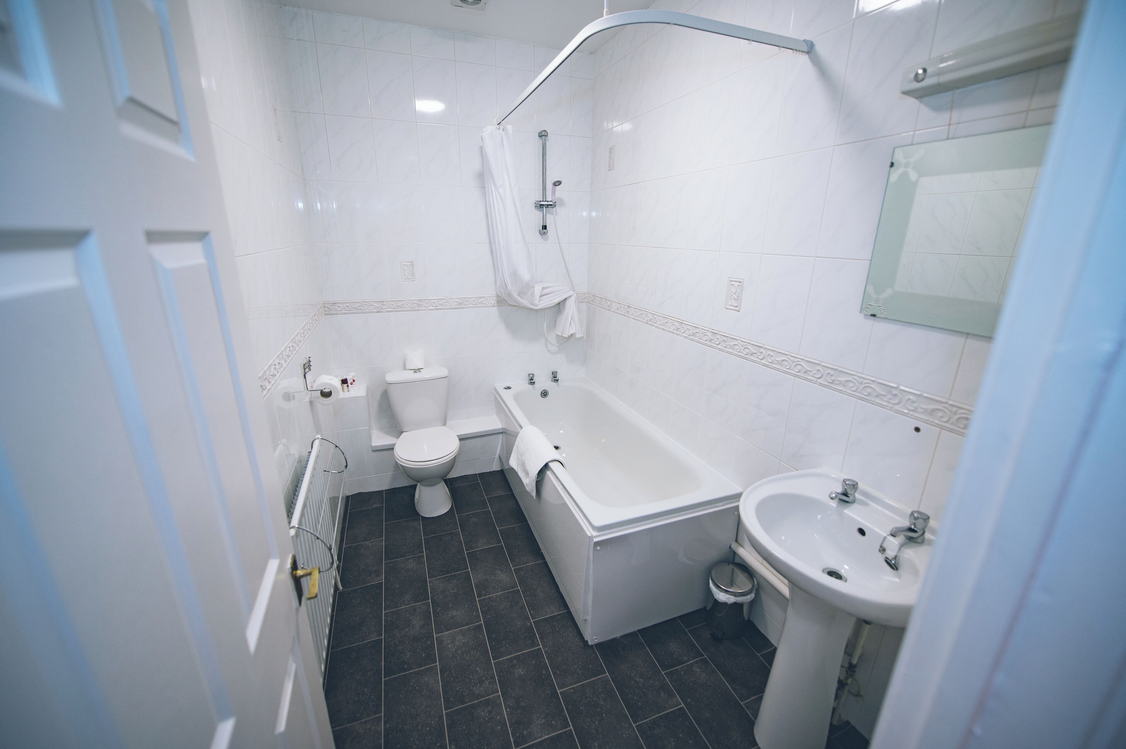 A bathroom with a bathtub, toilet, and sink.