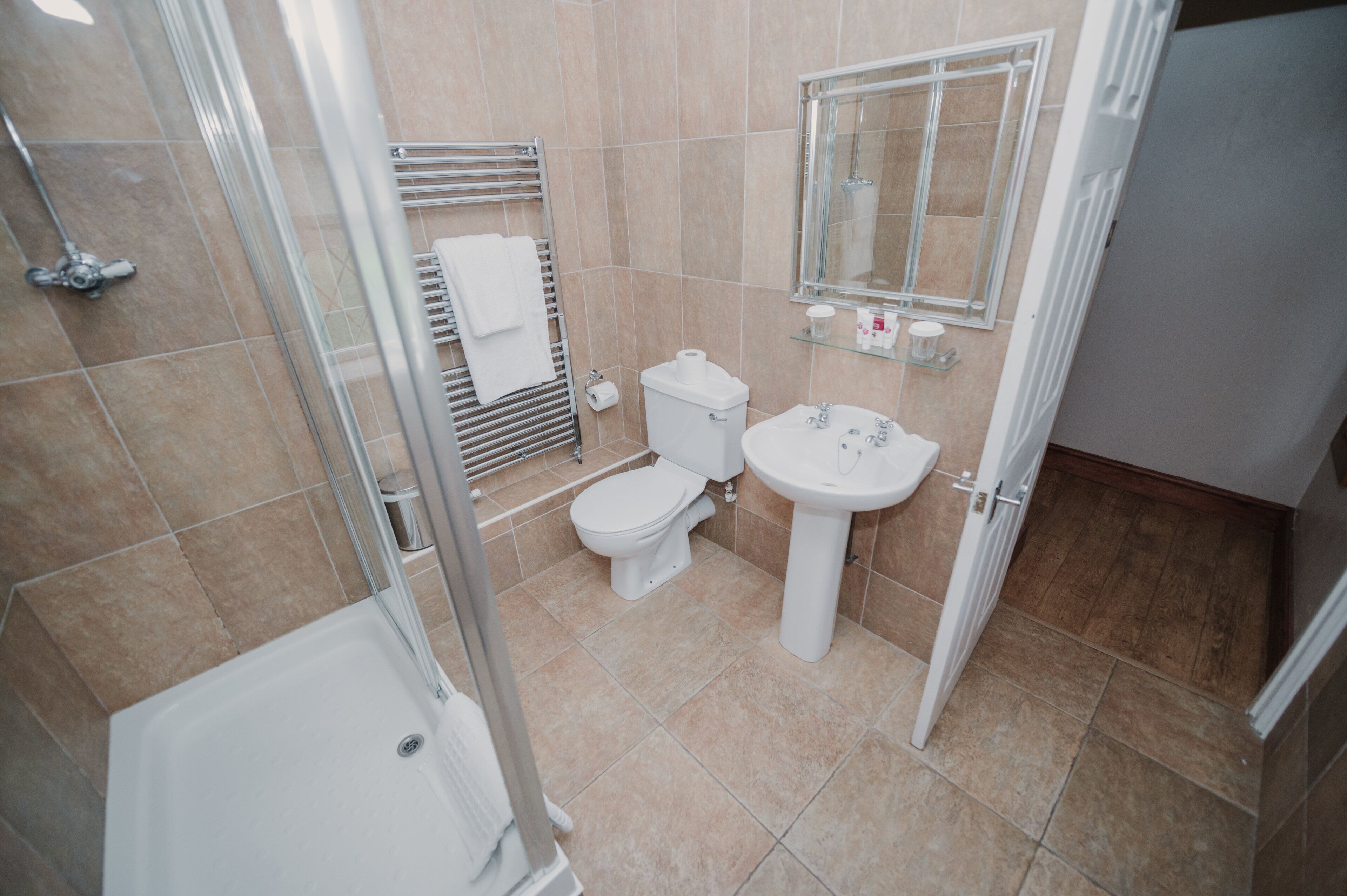 A modern bathroom with a shower, toilet, and sink.
