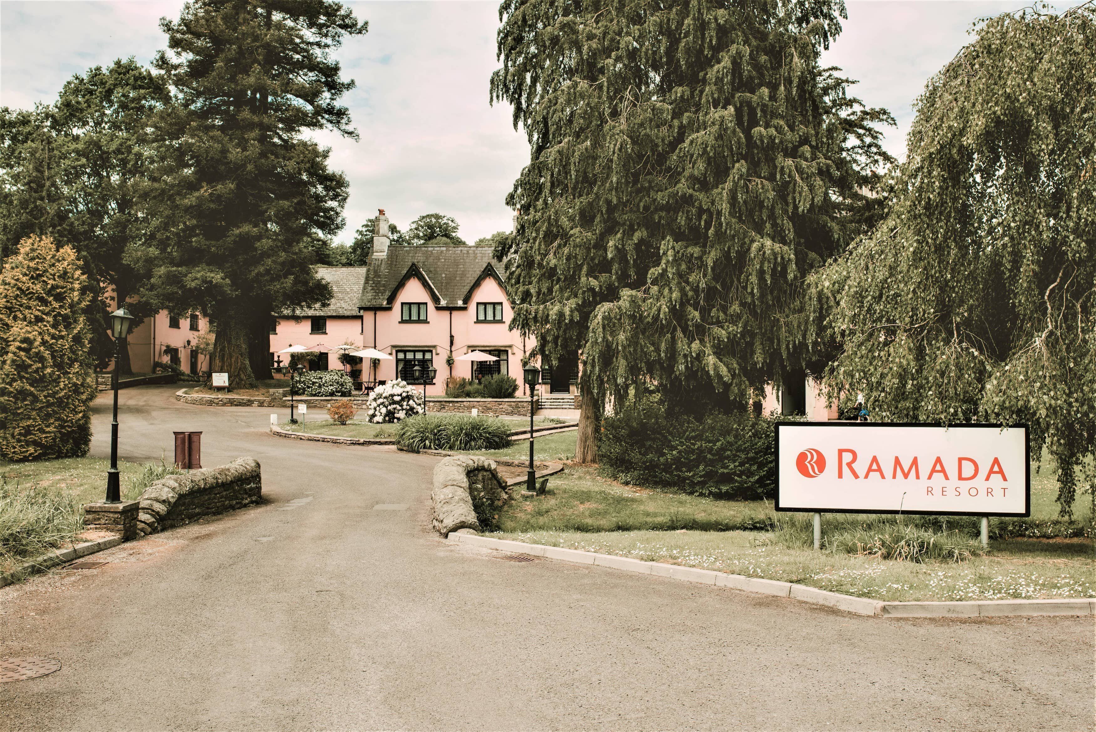 En stor, rosa byggnad med en skylt som visar texten ”Ramada Resort”.