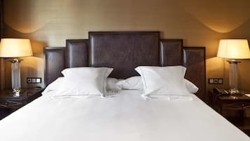 A hotel room with a large bed, two bedside tables with lamps, and a wooden headboard.
