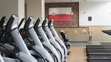 A gym with stationary bikes labeled MATRIX, a brick wall, and a sign for Altafit gym club.