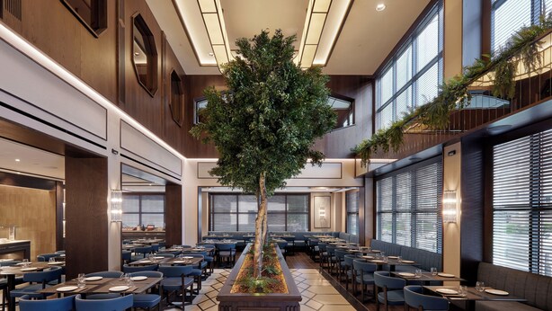 Un restaurante espacioso con un jardín vertical central, varias zonas de estar y grandes ventanales que ofrecen luz natural.