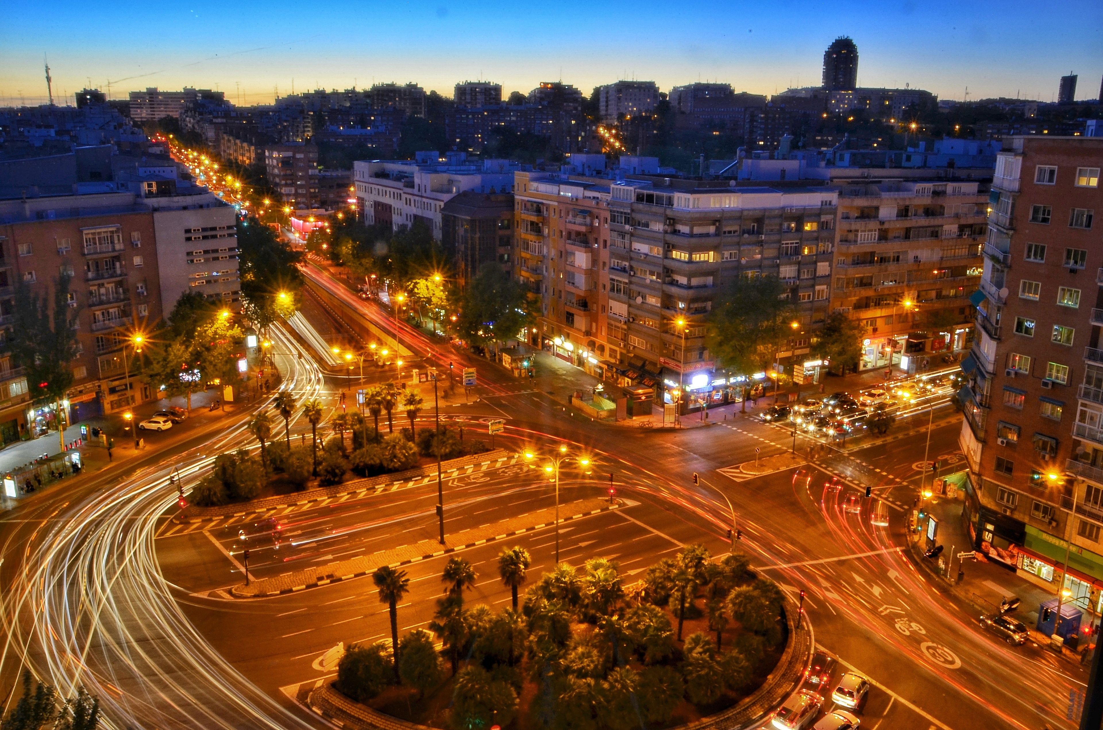 A cityscape at dusk with illuminated streets and buildings.