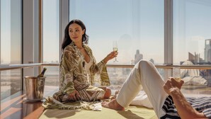 Une pièce avec une grande fenêtre, une bouteille de champagne et un verre sur une table.