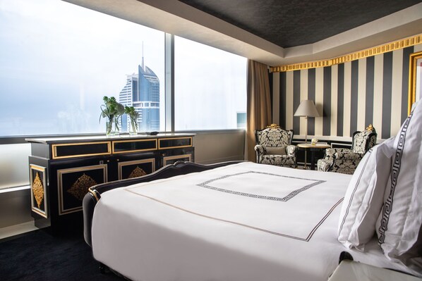 Une chambre d’hôtel avec un grand lit, un bureau et une vue sur les toits de la ville.