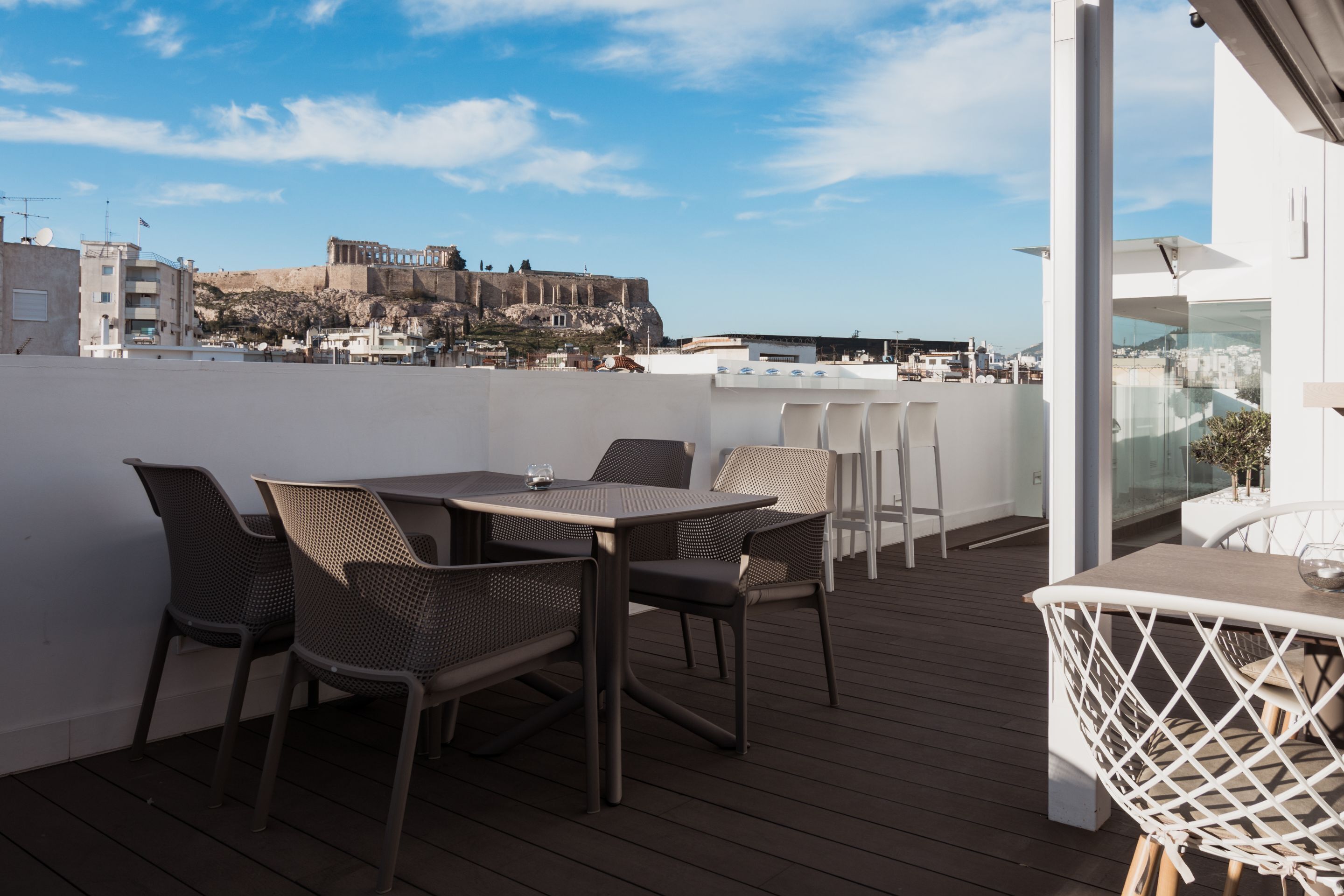 Un patio al aire libre con una mesa y sillas, con vistas a un edificio histórico y al paisaje urbano.
