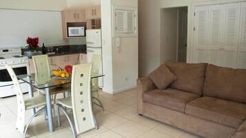 A compact living space with a kitchenette, dining area, and a sofa.