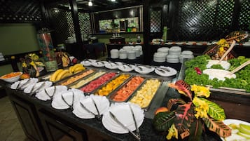 A buffet setup with various food items and utensils.