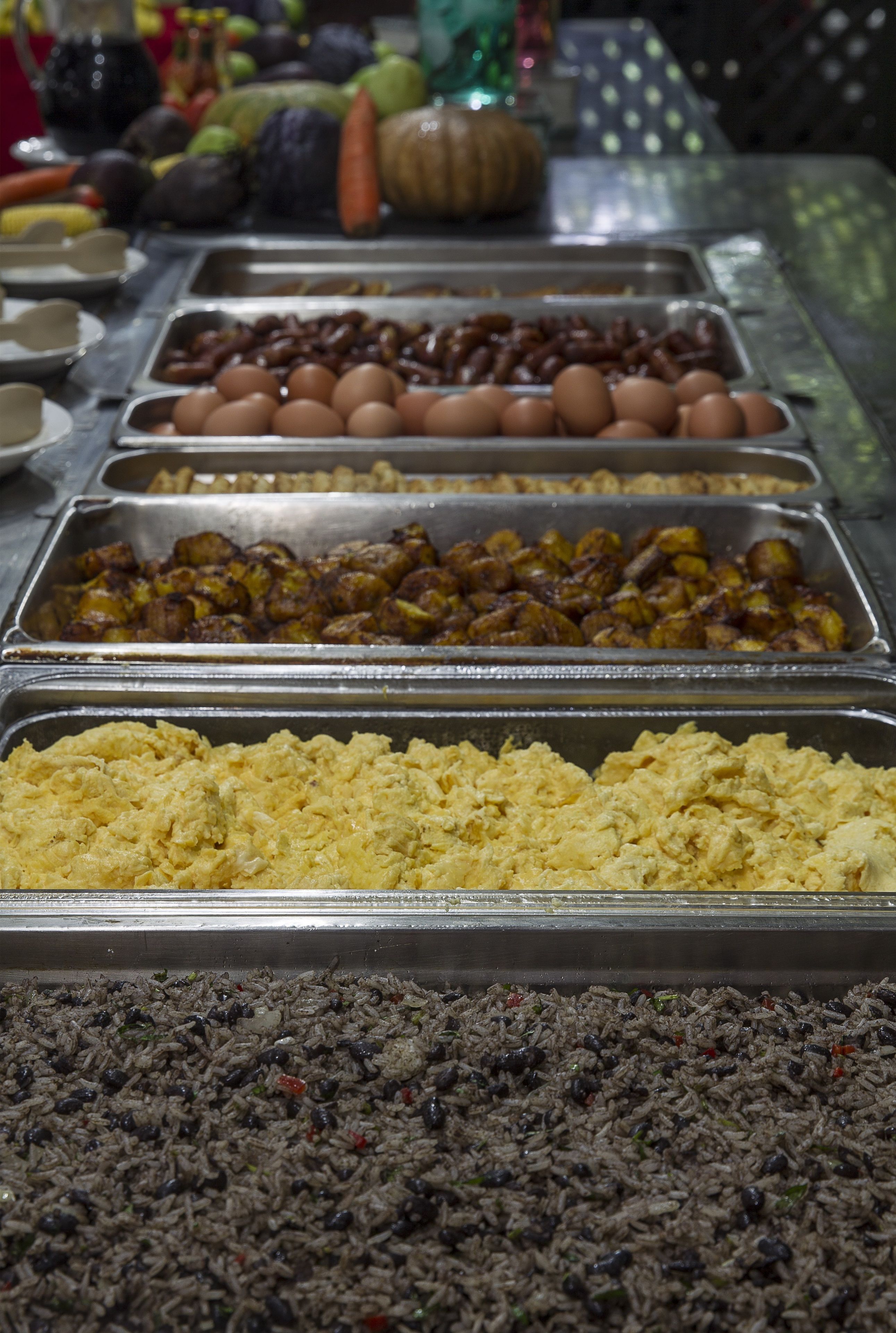 A buffet with various food items including eggs, roasted potatoes, and rice.