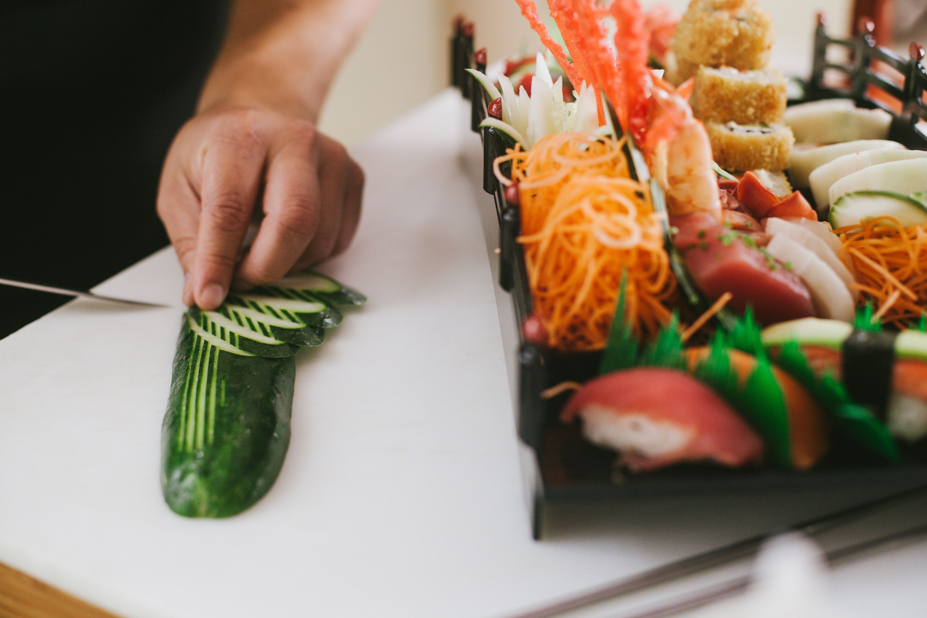 A sushi platter with various types of sushi and garnishes.