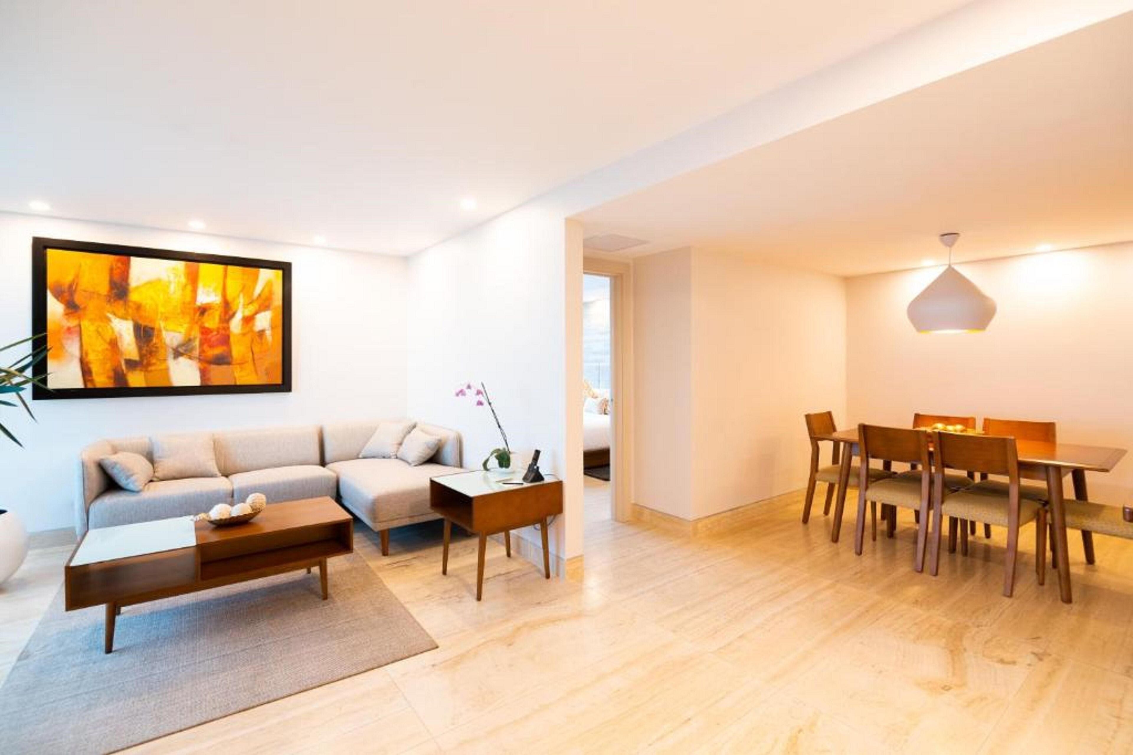 Ein modernes Wohnzimmer mit einer Couch, einem Couchtisch und einem Esstisch mit Stühlen.