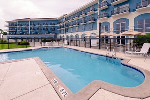 A swimming pool with a 15m/50ft depth, surrounded by a building with multiple balconies and outdoor seating.