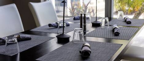 Una mesa de conferencias con posavasos, un vaso y una botella.