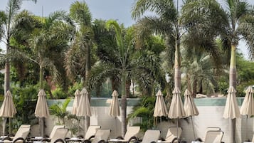 Piscine extérieure, parasols de plage, chaises longues