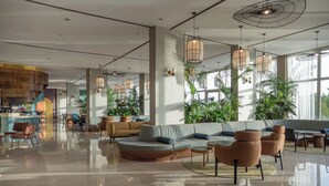 Un vestíbulo amplio con una zona de estar moderna, ventanas grandes y plantas de interior.