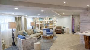 Una sala de estar moderna con un sofá, sillones, una mesita de centro y una estantería.
