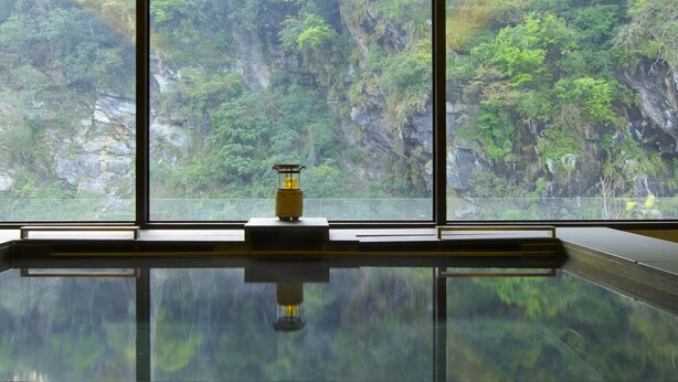 A room with a large window offering a view of a forested cliff. - Silks Place Taroko (Xiulin)