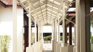 A covered walkway with stone steps and white pillars, leading to a building entrance. - Lao Plaza Hotel (Vientiane)