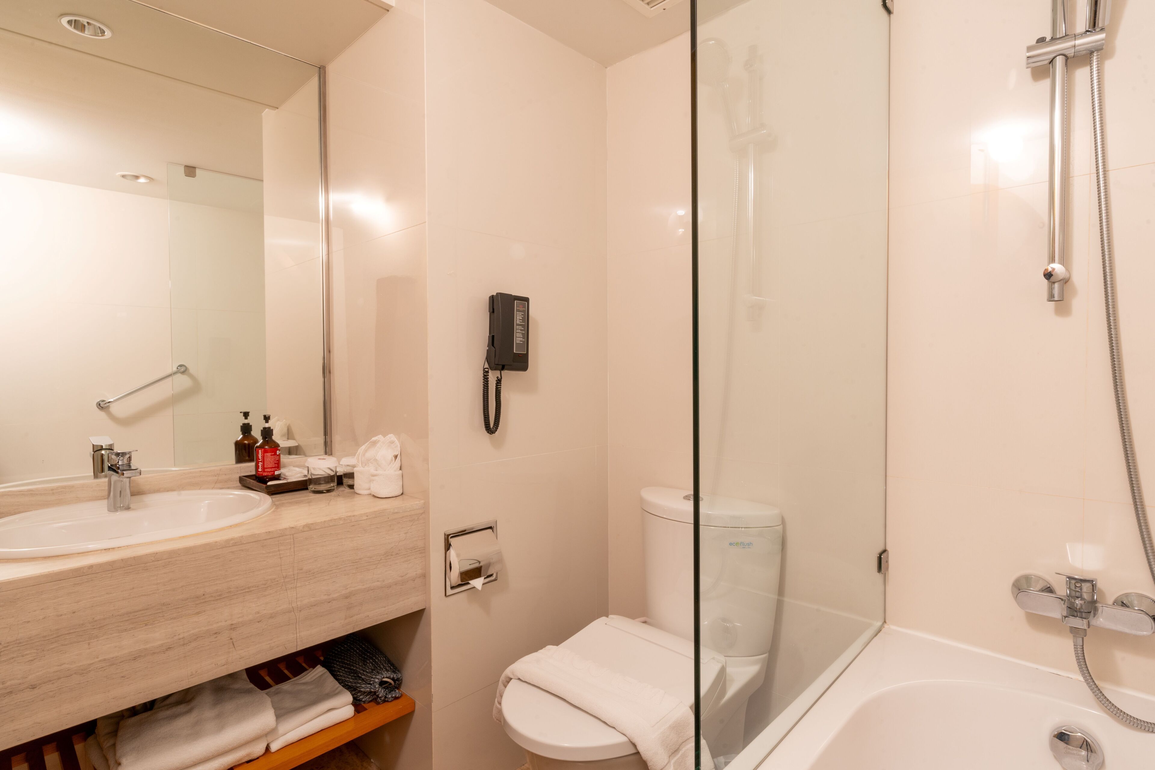 A modern bathroom with a glass-enclosed shower, a sink with a mirror, and a toilet.