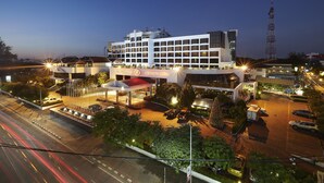 A modern hotel with a prominent sign, multiple floors, and a parking area. - Lao Plaza Hotel (Vientiane)