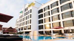 A hotel with a swimming pool, outdoor seating, and a modern architectural design. - Lao Plaza Hotel (Vientiane)