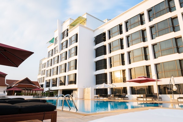 A hotel with a swimming pool, outdoor seating, and a modern architectural design. - Lao Plaza Hotel (Vientiane)