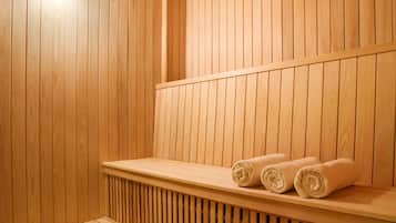 A wooden sauna with benches and towels.