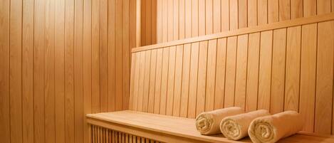 A wooden sauna with benches and towels.