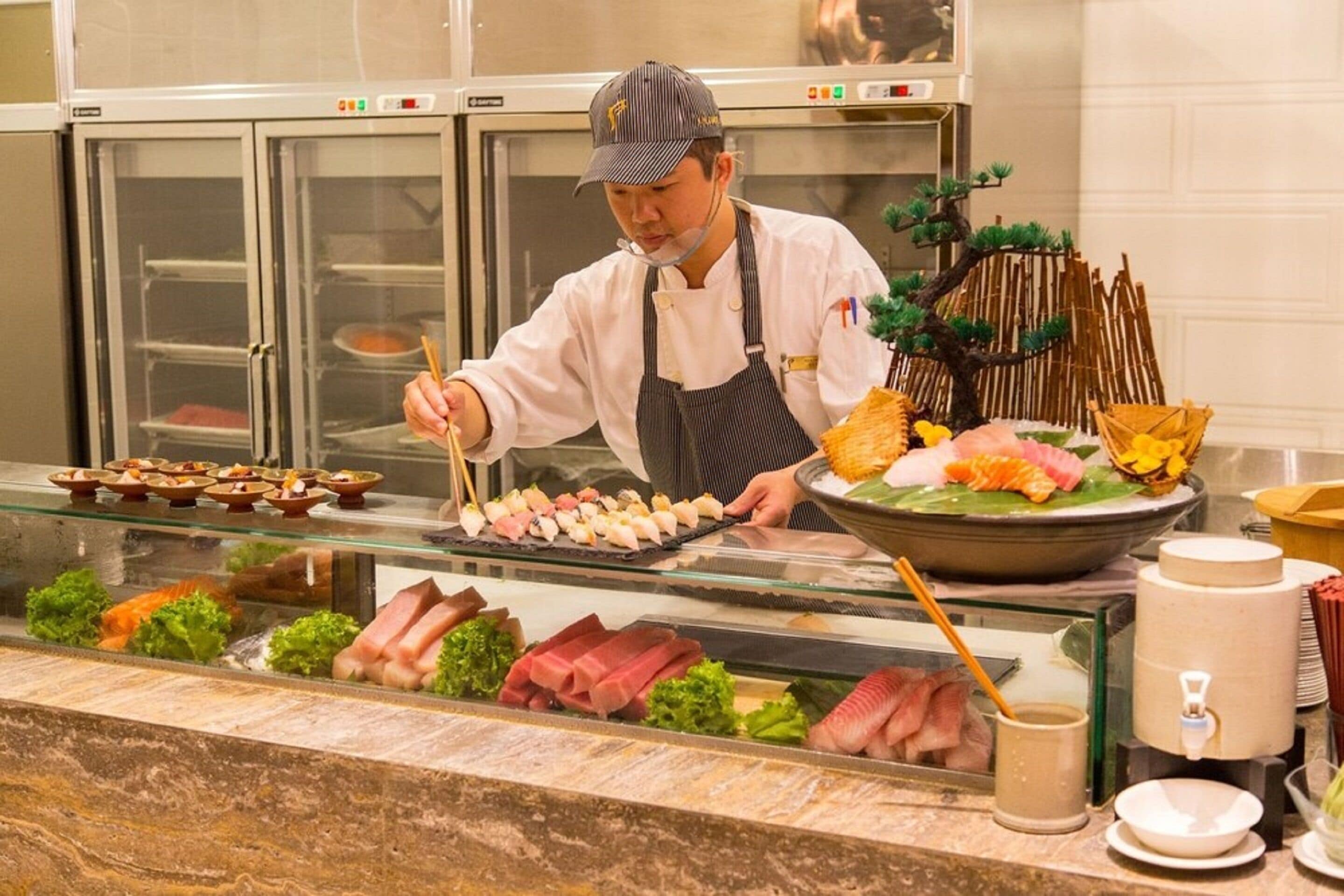 A sushi bar with various types of sushi and sashimi displayed.