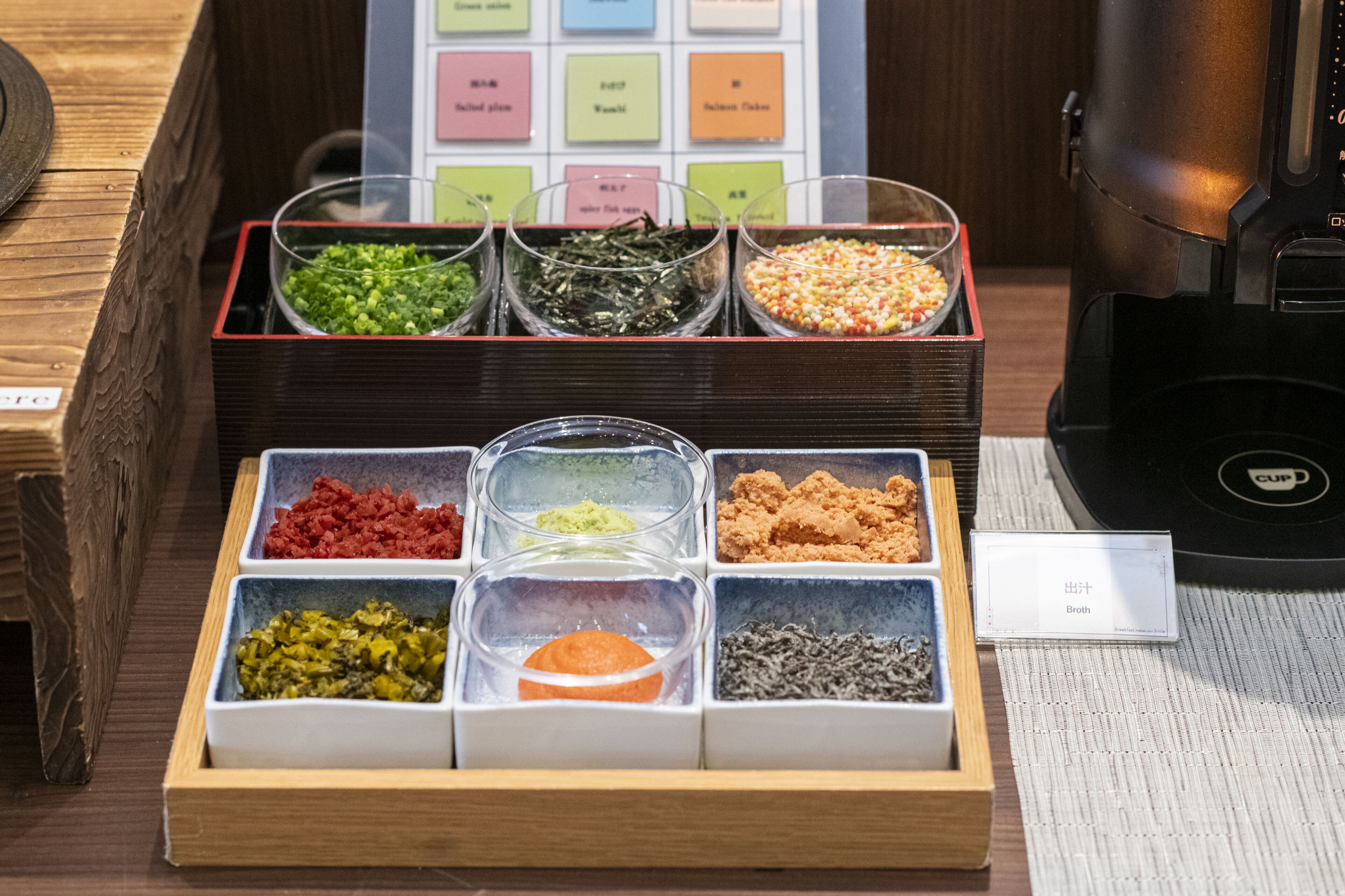 A food display with various condiments and ingredients in clear containers.